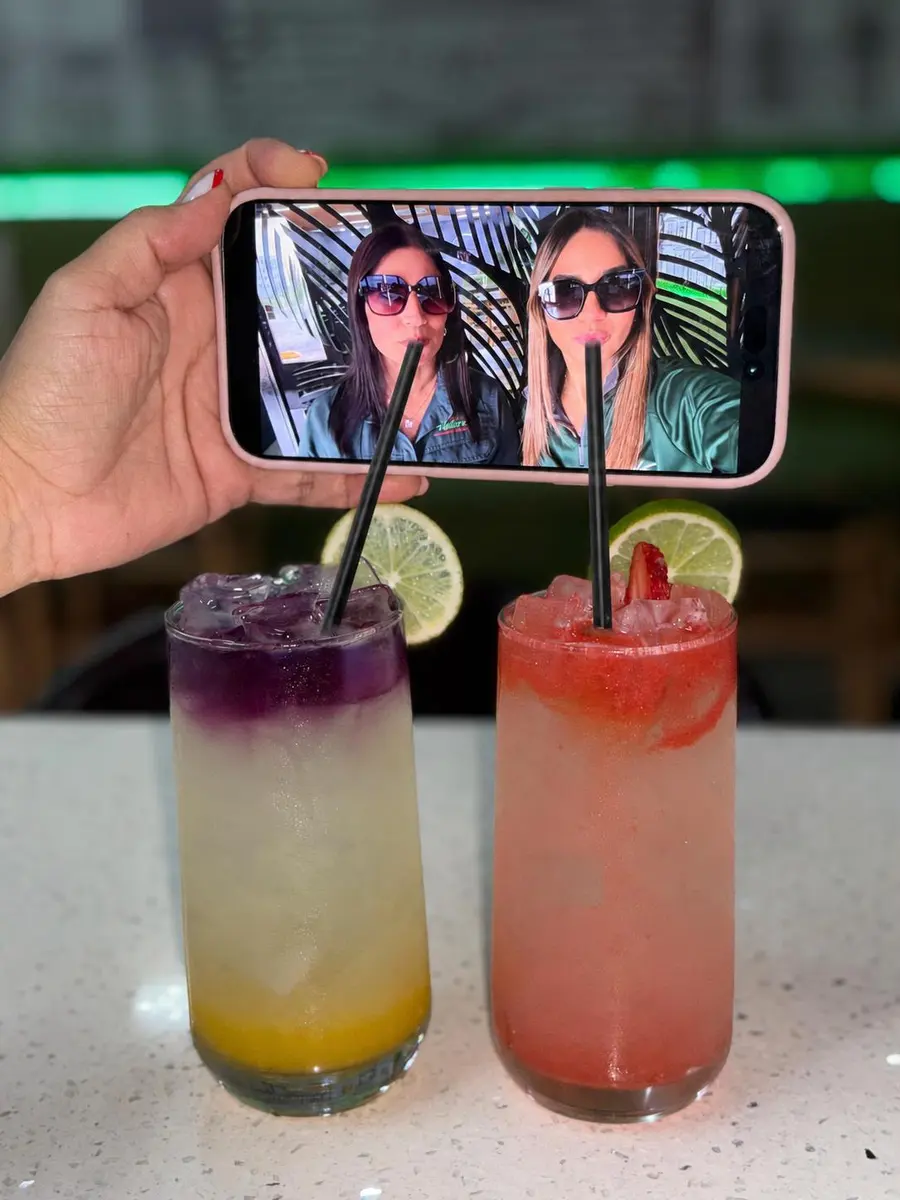 Clientas tomándose una foto con dos bebidas de la casa