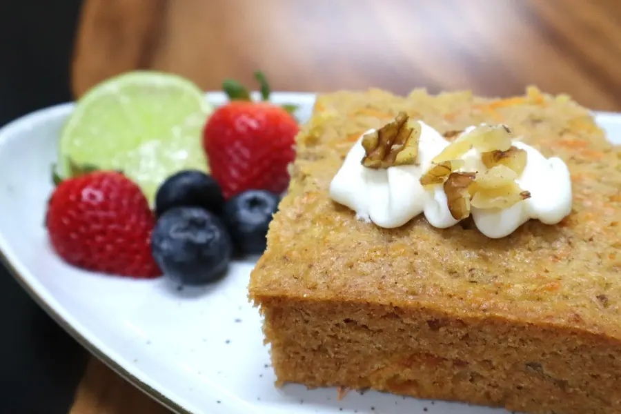 Rebanada de bizcocho de zanahoria con crema y nueces