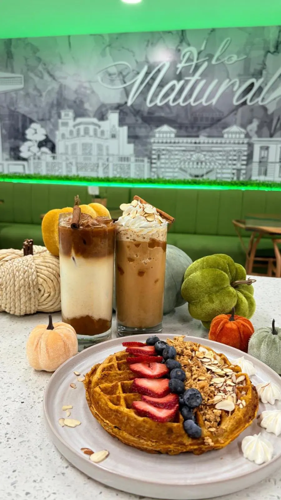 Dos cafés helados y waffle con frutos rojos, decoración de otoño